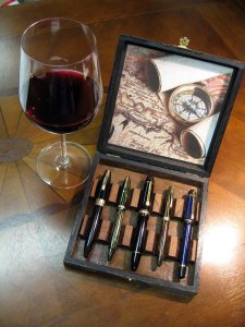 Map box open with pens and wine glass